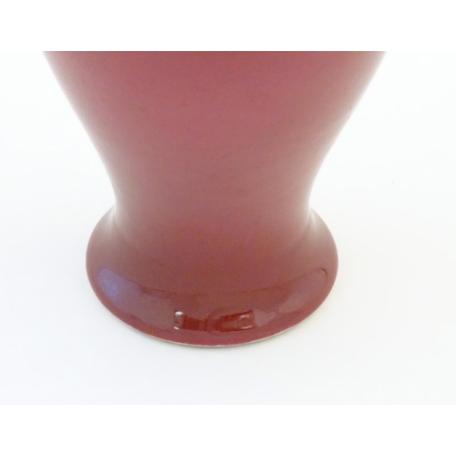 11 - A Chinese baluster vase with a bulbous rim, with a ruby pink glaze and a turquoise interior. Charact... 