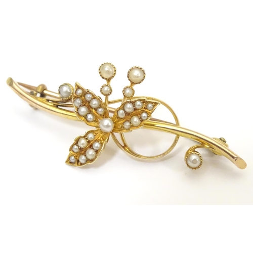 A 15ct gold brooch with floral detail set with seed pearl. Approx. 2" wide