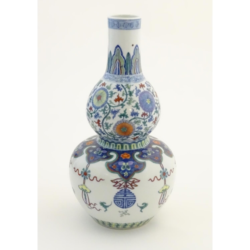12 - A Chinese double gourd vase with doucai style decoration with scrolling floral and foliate detail. C... 
