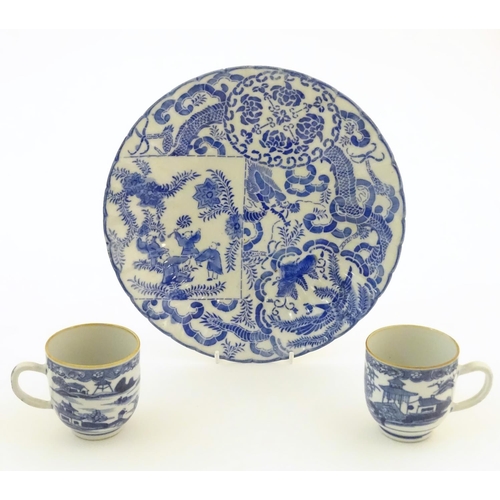 19 - An Oriental blue and white plate decorated with figures and scrolling flowers and foliage. With blue... 