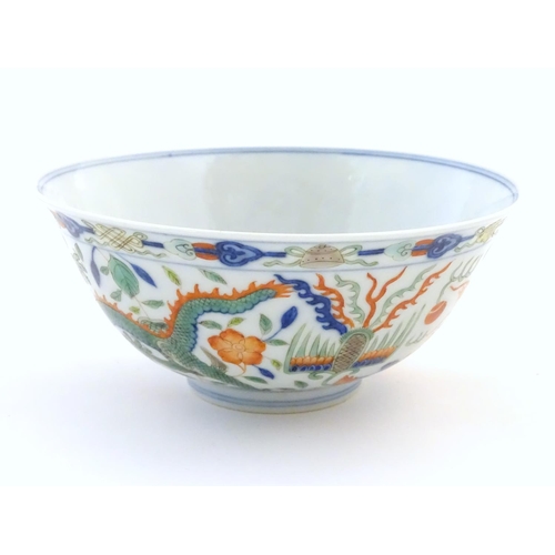 24 - A Chinese bowl with dragon and flaming pearl detail, with flowers, foliate and stylised clouds. Char... 