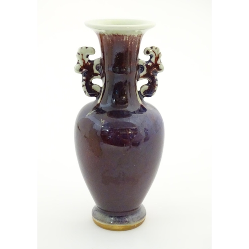 29 - An Oriental twin handled vase, the handles with foliate detail. Approx. 8