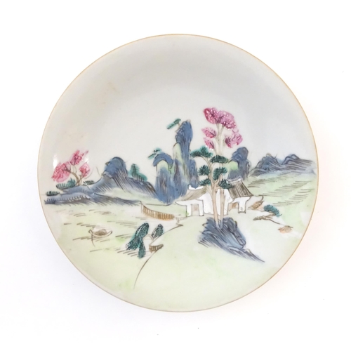 16A - A Chinese plate decorated with a landscape scene with a boat on a river. With red foliate motifs to ... 
