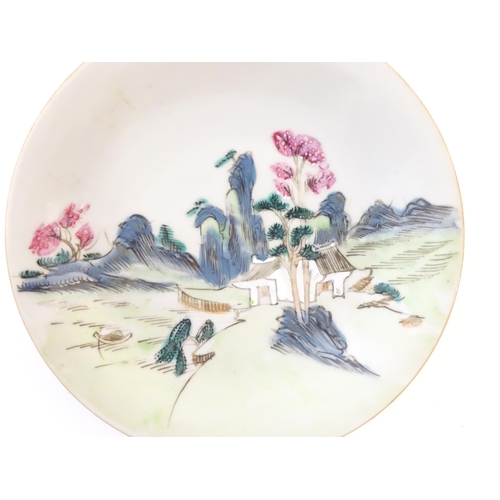 16A - A Chinese plate decorated with a landscape scene with a boat on a river. With red foliate motifs to ... 