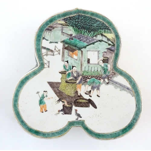 44 - A Chinese famille verte stand of trefoil form depicting figures sifting grain and shooing chickens. ... 