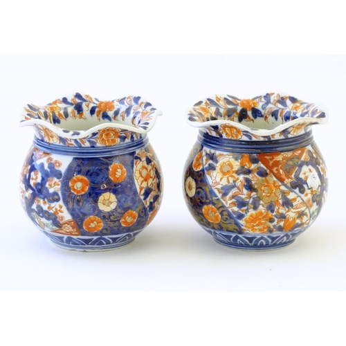47 - Two Oriental vases of bulbous form with flared rims decorated in the Imari palette with flowers and ... 