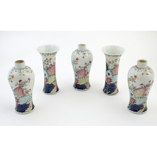 12 - Five Chinese famille rose vases comprising two trumpet vases with floral and foliate detail, and thr... 