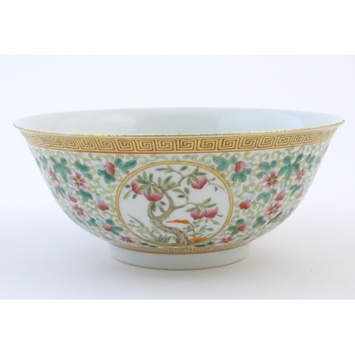 35 - A Chinese famille verte bowl decorated with fruiting trees and landscapes scenes in roundels and scr... 
