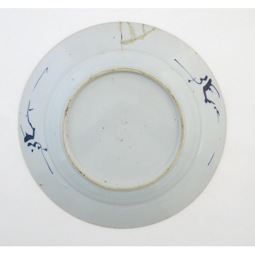 59 - A Chinese blue and white plate decorated with flowers and foliage. With stylised motifs to reverse. ... 
