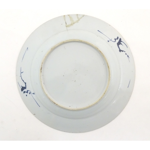 59 - A Chinese blue and white plate decorated with flowers and foliage. With stylised motifs to reverse. ... 