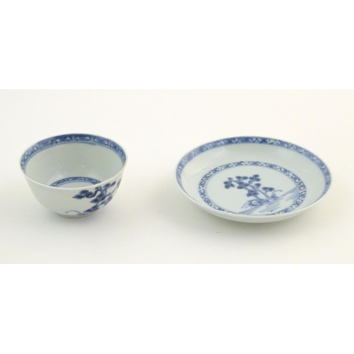 11 - A Chinese Nanking Cargo blue and white tea bowl and saucer, decorated with pine trees and banded bor... 