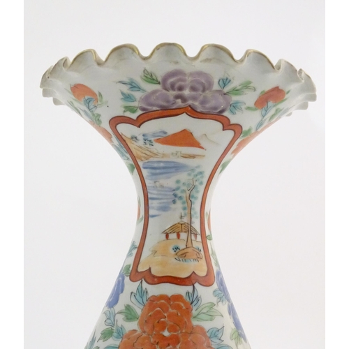 16 - A Japanese vase with a flared rim and scalloped edge, decorated with two figures in a landscape with... 