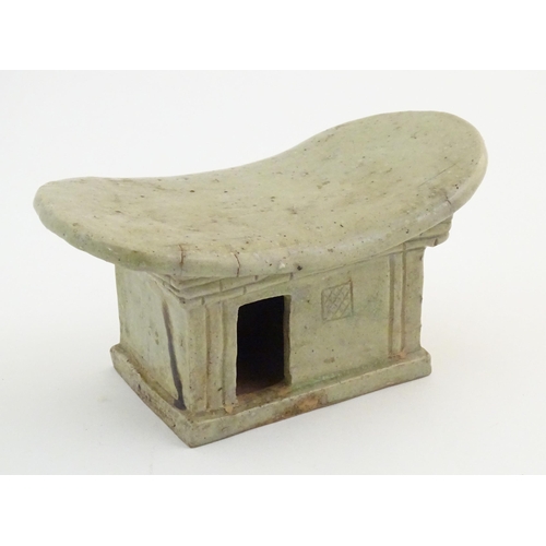 54 - An Oriental stoneware neck pillow / headrest with architectural / building detail. Approx. 4 1/4