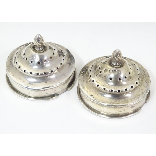 274 - A pair of silver pepperettes of urn shape with bow and swag detail and blue glass liners. Hallmarked... 