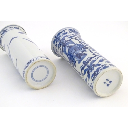 32 - Two Oriental blue and white vases of cylindrical form, one depicting figures in a garden scene with ... 