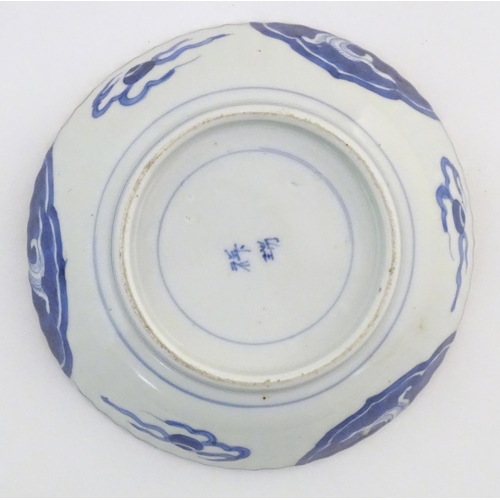 55 - An Oriental blue and white dish with fluted rim, decorated with auspicious scroll symbols, wreaths a... 