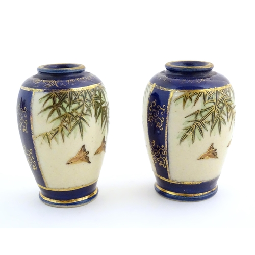 31 - A pair of small Japanese vases decorated with birds and foliage with gilt highlights. Character mark... 