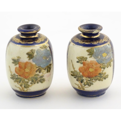 33 - A pair of small Japanese vases decorated with flowers and foliage with gilt highlights. Character ma... 