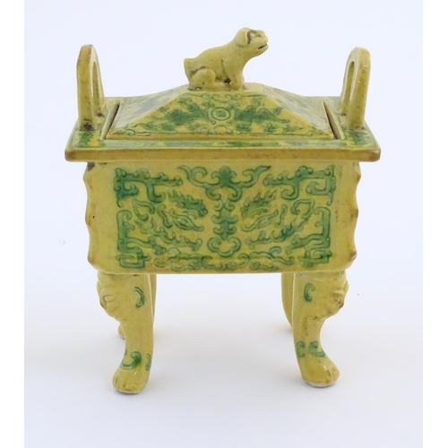 52 - A Chinese rectangular censer with a yellow ground, raised on 4 paw footed legs, with twin upright ha... 