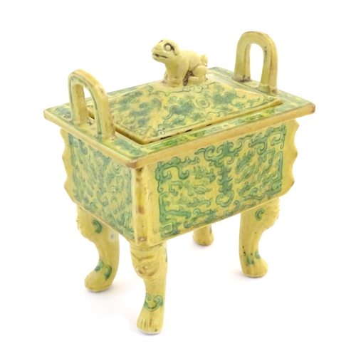 52 - A Chinese rectangular censer with a yellow ground, raised on 4 paw footed legs, with twin upright ha... 