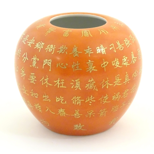 53 - A small Chinese vase of squat form with an orange ground and gilt character script decoration to bod... 
