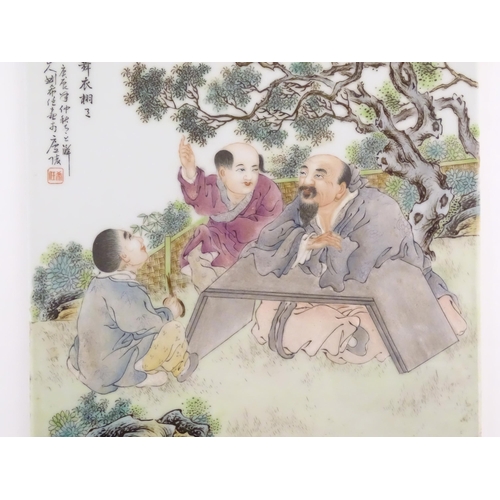 56 - A Chinese porcelain plaque decorated with three seated male figures in a garden terrace watching but... 