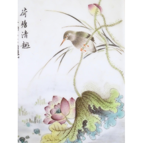 59 - A Chinese porcelain plaque decorated with a bird perched on the stem of a stylised flower. Character... 