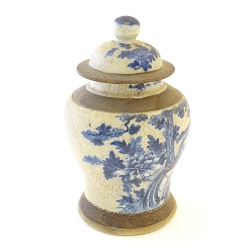 14 - A Chinese blue and white ginger jar with a crackle glaze, the body decorated with a bird in a tree, ... 