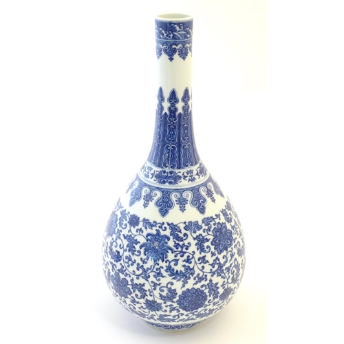 2 - A Chinese blue and white bottle vase decorated with scrolling flowers and foliage, the neck with ban... 