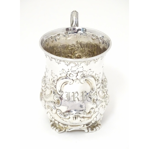 296 - A Victorian silver christening mug with embossed floral and C-scroll decoration. Hallmarked Sheffiel... 