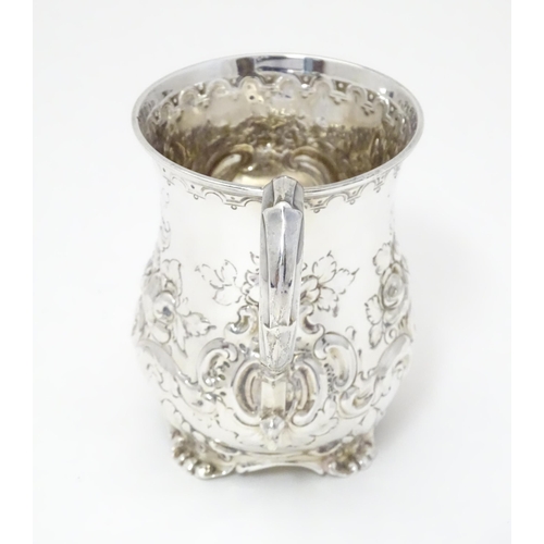 296 - A Victorian silver christening mug with embossed floral and C-scroll decoration. Hallmarked Sheffiel... 