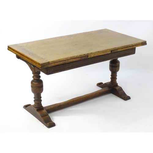2041 - An early 20thC oak draw leaf table with a trestle style base. 54