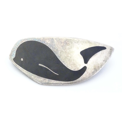 675 - Scandinavian Jewellery: A Danish silver brooch with black enamel whale decoration, marked Meka, Ster... 