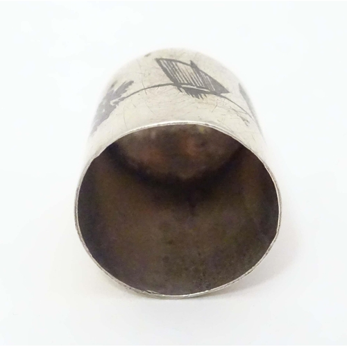 501 - A white metal thimble with niello decoration depicting a river Nile landscape with boats.