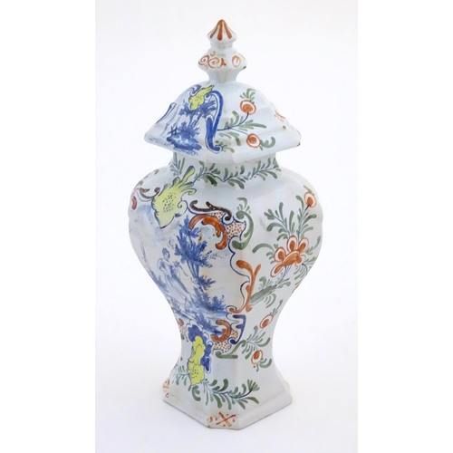 26 - A Continental faience style vase and cover with painted decoration depicting a young lady holding a ... 
