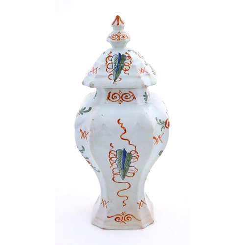 26 - A Continental faience style vase and cover with painted decoration depicting a young lady holding a ... 