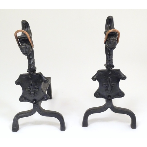 37 - A pair of early 20thC cast fire dogs with cast dragon head and a scrolling shield with fleur de lys ... 