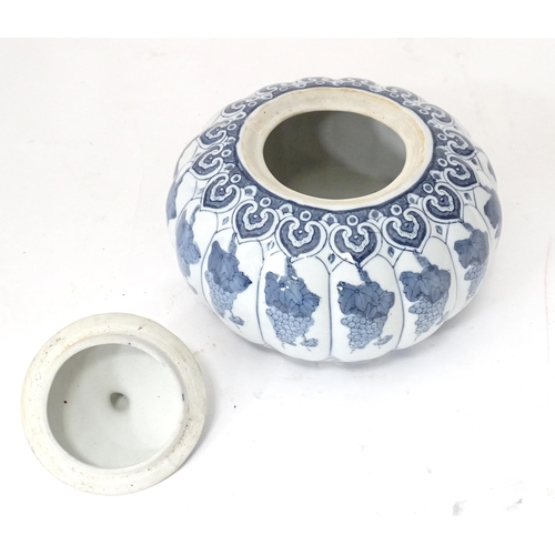 31 - A Chinese blue and white pot and cover of stylised gourd / pumpkin form decorated with banded vine a... 
