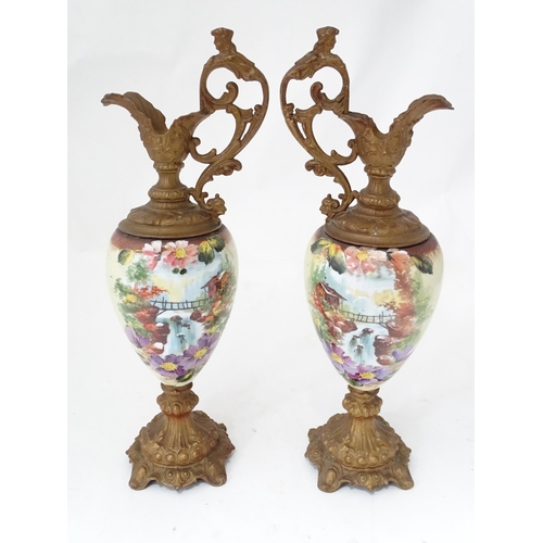 33 - A pair of hand painted glass ewers with gilt metal mounts. Approx. 21