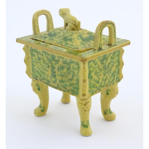 11 - A Chinese rectangular censer with a yellow ground, raised on 4 paw footed legs, with twin upright ha... 