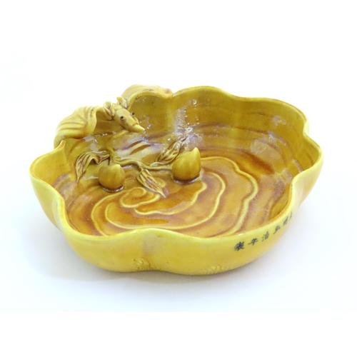 16 - A Chinese fluted edged yellow brush wash dish with relief bat and fruit decoration. Character marks ... 