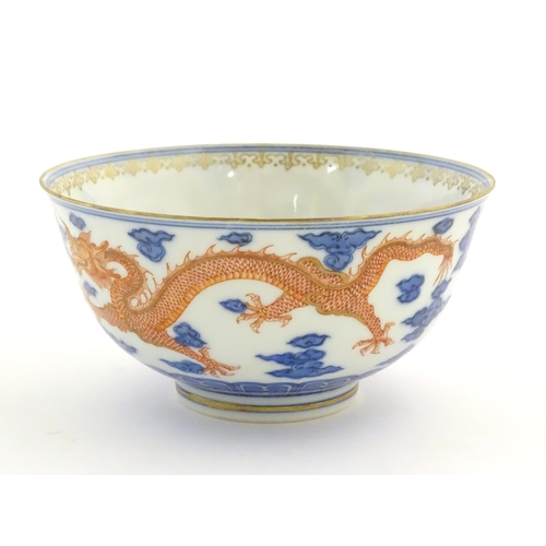 35 - A Chinese blue and white dragon bowl decorated with red dragons, flaming pearl and stylised clouds. ... 