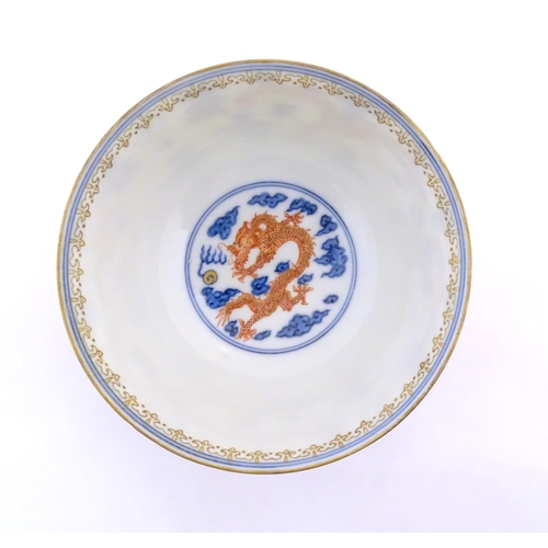 35 - A Chinese blue and white dragon bowl decorated with red dragons, flaming pearl and stylised clouds. ... 