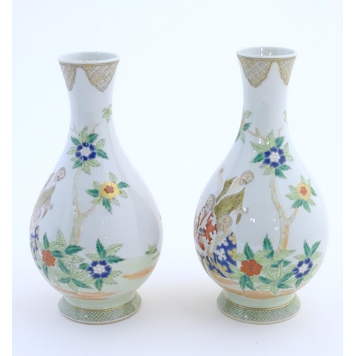 43 - A pair of Chinese famille rose bottle vases decorated with seated figures on a garden terrace, with ... 