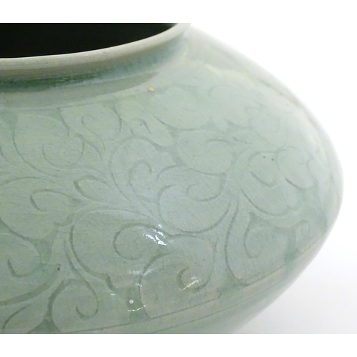 48 - A Chinese celadon style vase of squat form with relief foliate decoration. Character marks to base. ... 