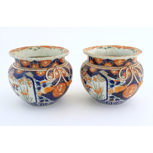 58 - A pair of Oriental planters / jardinieres decorated in the Imari with flowers, foliage and tassel bo... 