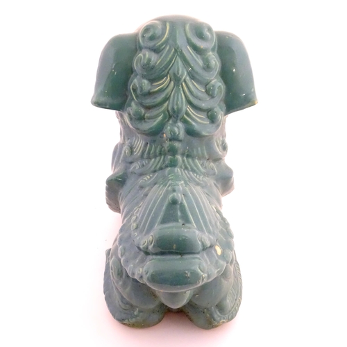 59 - An Oriental model of a guardian lion with a turquoise glaze. Approx. 16