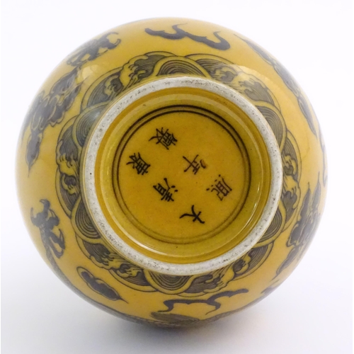 1 - A Chinese bottle vase with a yellow ground decorated with a dragon amongst stylised clouds. Characte... 
