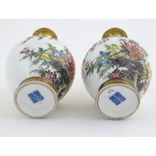 3 - A pair of Chinese vases decorated with birds, flowers and blossom trees, with gilt detail to necks a... 