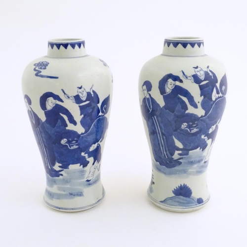 44 - A pair of Chinese blue and white vases decorated with a Chinese dragon parade with figures in a land... 